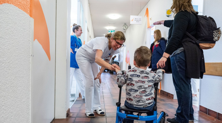 Eine Pflegefachfrau begrüsst das Kind vor einer Untersuchung in der Poliklinik