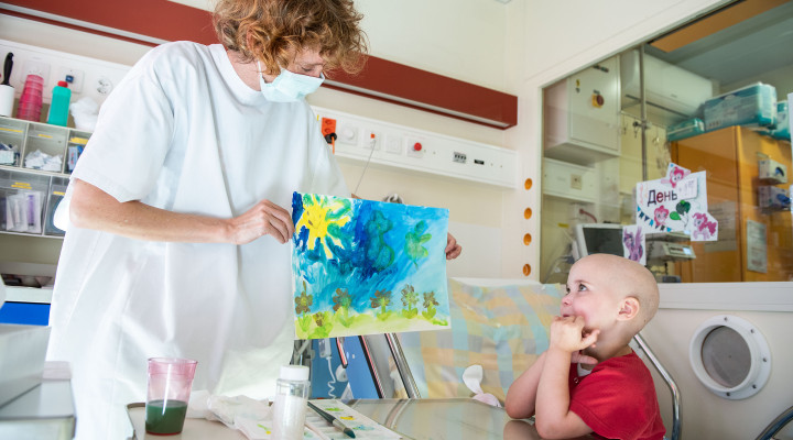 Kunsttherapeutin Barbara Carnielli bewundert eine Malerei von einem kranken Kind auf der Stammzelltransplantationsstation