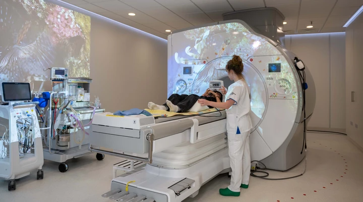 Eine Radiologiefachfrau bereitet ein Kind für eine radiologische Untersuchung im Kinderspital Zürich vor