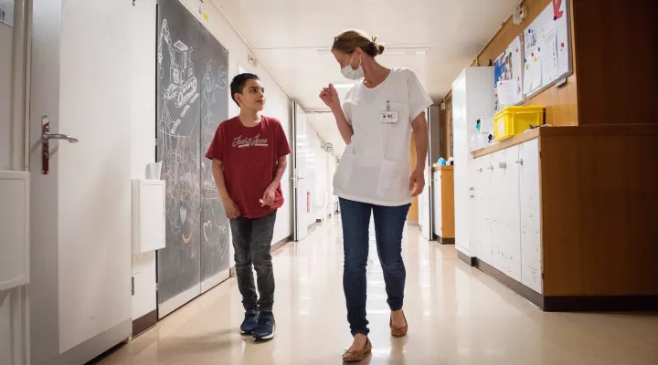 Junger Diego läuft mit Ärztin Sophie Böttcher im alten Kinderspital.