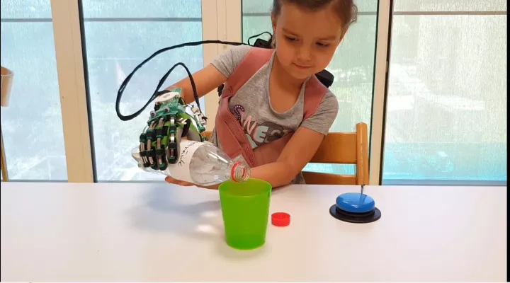 Patient schenkt sich Wasser ein mit Hand-Exkoskelett