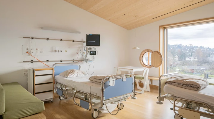 Ein Zweibett-Patientenzimmer mit ausziehbareren Liegebänken für ein je ein übernachtendes Familienmitglied