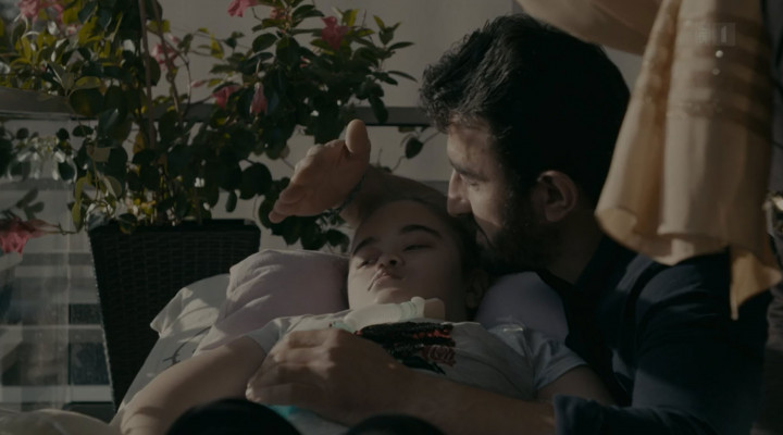 Ein Vater schützt seine totkranke Tochter mit seiner Hand vor der Sonne.