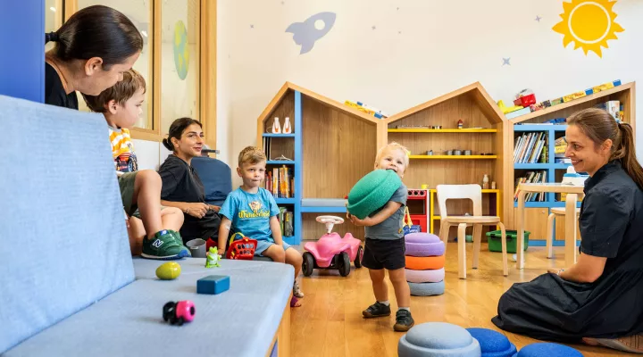 Kinder und Erwachsene spielen und entspannen in einem Spielzimmer im Akutspital des Kinderspitals Zürich