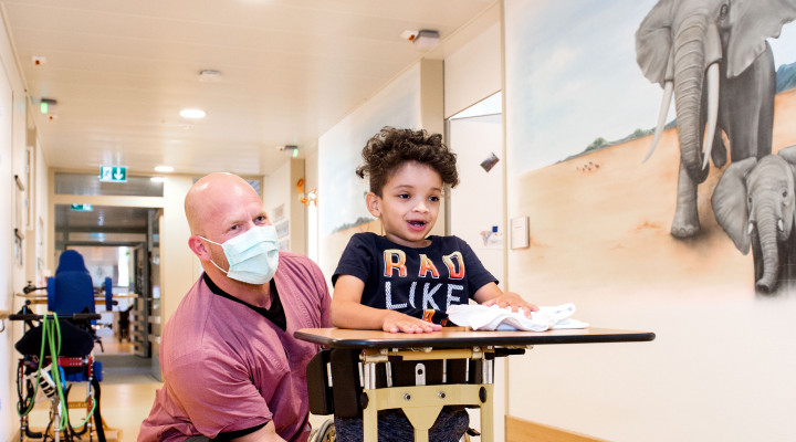 Kinder-Reha Schweiz, Pflegefachmann mit Patient im Gang der Station