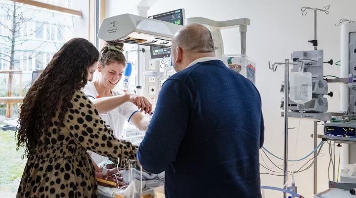 Eine Pflegefachfrauberatet Eltern von einem Baby.