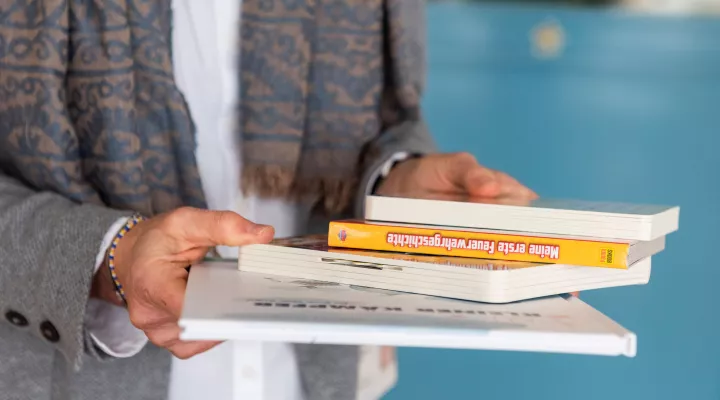 Vier Bücher in den Händen von der Direktorin der Spitalschule