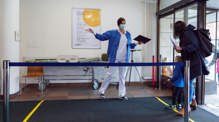 Eine Pflegefachfrau weisst den Weg zur Anmeldung während der Corona Pandemie