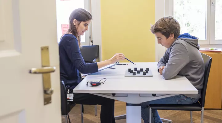 Ein Junge löst eine Aufgabe während einer Untersuchung in der Abteilung Entwicklungspädiatrie