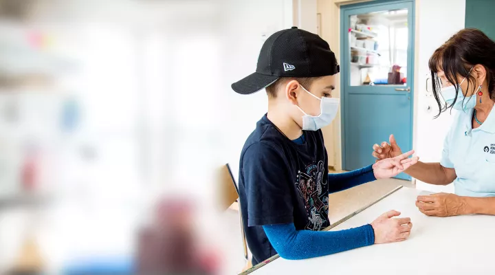 Ergotherapeutin behandelt die Hände eines brandverletzten Patienten