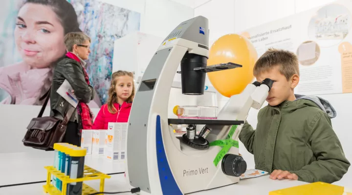 Kind probiert Mikroskop aus 