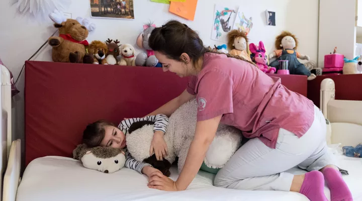 Eine Pflegefachfrau hilft einem Mädchen mit einer Behinderung