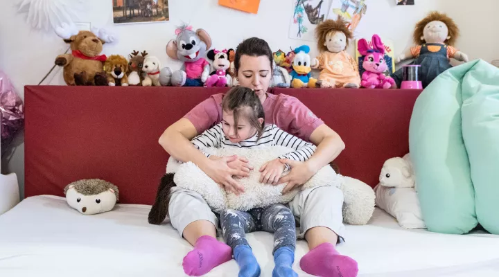 Kinder-Reha Schweiz, Pflegefachfrau mit Patientin, beide sitzend am Boden