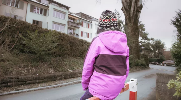 Kind von hinten mit lila Jacke