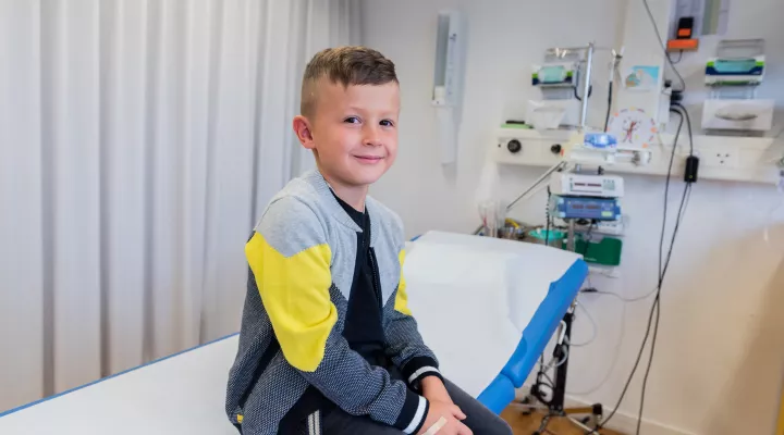 Patient sitzt auf Behandlungsliege