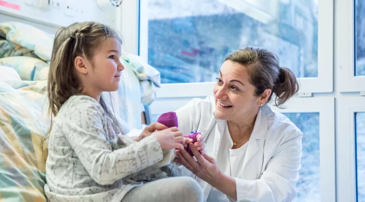 Moyamoya, ​Prof. Dr. med. Nadia Khan, Leitende Ärztin, auf Visite bei einer Patientin im Spitalzimmer