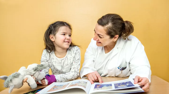 Moyamoya, Prof. Dr. med. Nadia Khan, Leitende Ärztin, erklärt einer Patientin im Spitalzimmer die Krankheit mit einem Kinderbuch