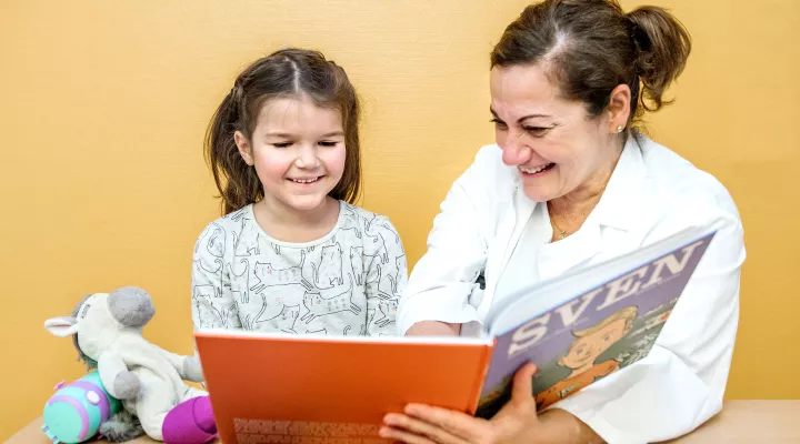 Moyamoya, ​Prof. Dr. med. Nadia Khan, Leitende Ärztin, erklärt einer Patientin im Spitalzimmer die Krankheit mit einem Kinderbuch