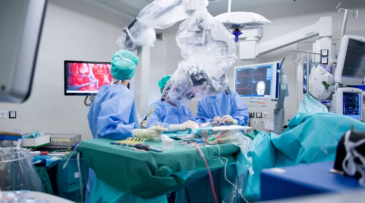 Neurochirurg Niklaus Krayenbühl mit seinem Team fotografiert währen einem Eingriff