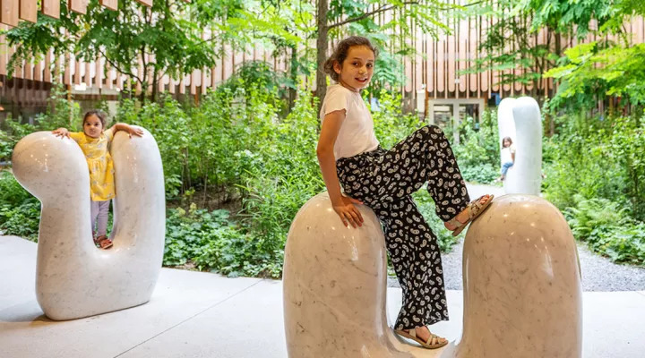 Neuropädiatrie, Kopfschmerzen, Mädchen sitzt im Eingangsbereich des Kinderspitals auf Hasenohren