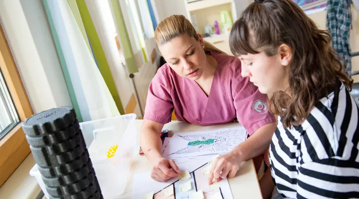 Kinder-Reha Schweiz, Pflegefachfrau erklärt Patientin Übungsablauf