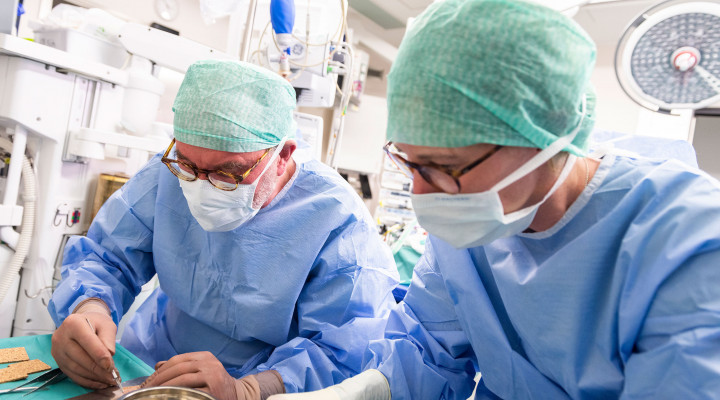 Prof. Dr. Clemens Schiestl und PD Dr. Sophie Böttcher im Operationssaal beim Vorbereiten von Haut zur Spalthauttransplantation 