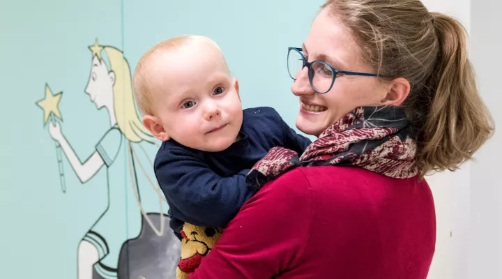 Spina bifida Patient auf Arm der Mutter 