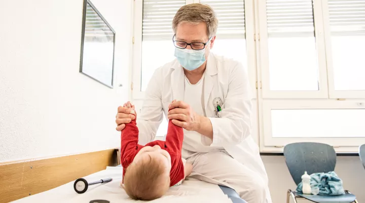 Ein Arzt untersucht ein Baby.