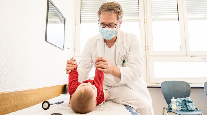 Ein Arzt untersucht ein Baby. 
