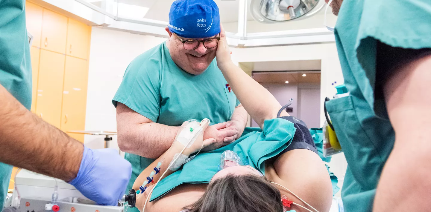 Ein Intimmoment direkt nach einer Operation eines Fetus im Bauch des Mutters, der Chirurg Martin Meuli hält die Hände der Patientinat
