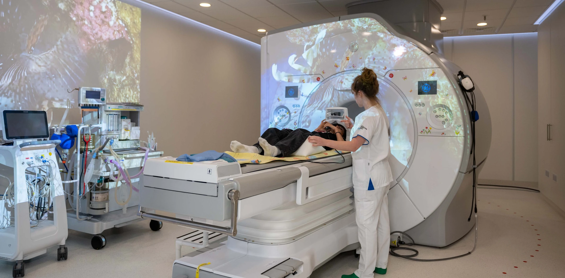 Eine Radiologiefachfrau bereitet ein Kind für eine radiologische Untersuchung im Kinderspital Zürich vor