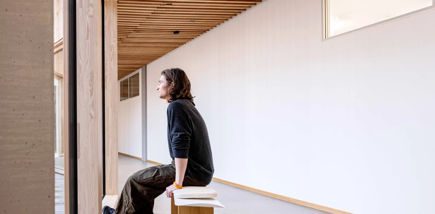 Der Snowboarder Iouri Podlatchikov sitzt auf einer Bank bestehend aus einem seiner alten Snowboards im Kinderspital Zürich