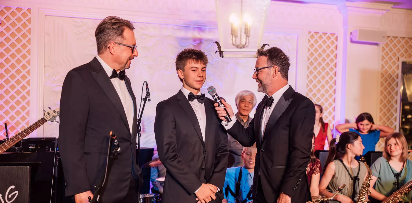 Patient Daniel im Gespräch mit Nik Hartmann und Michael Grotzer beim Kispiball 2025