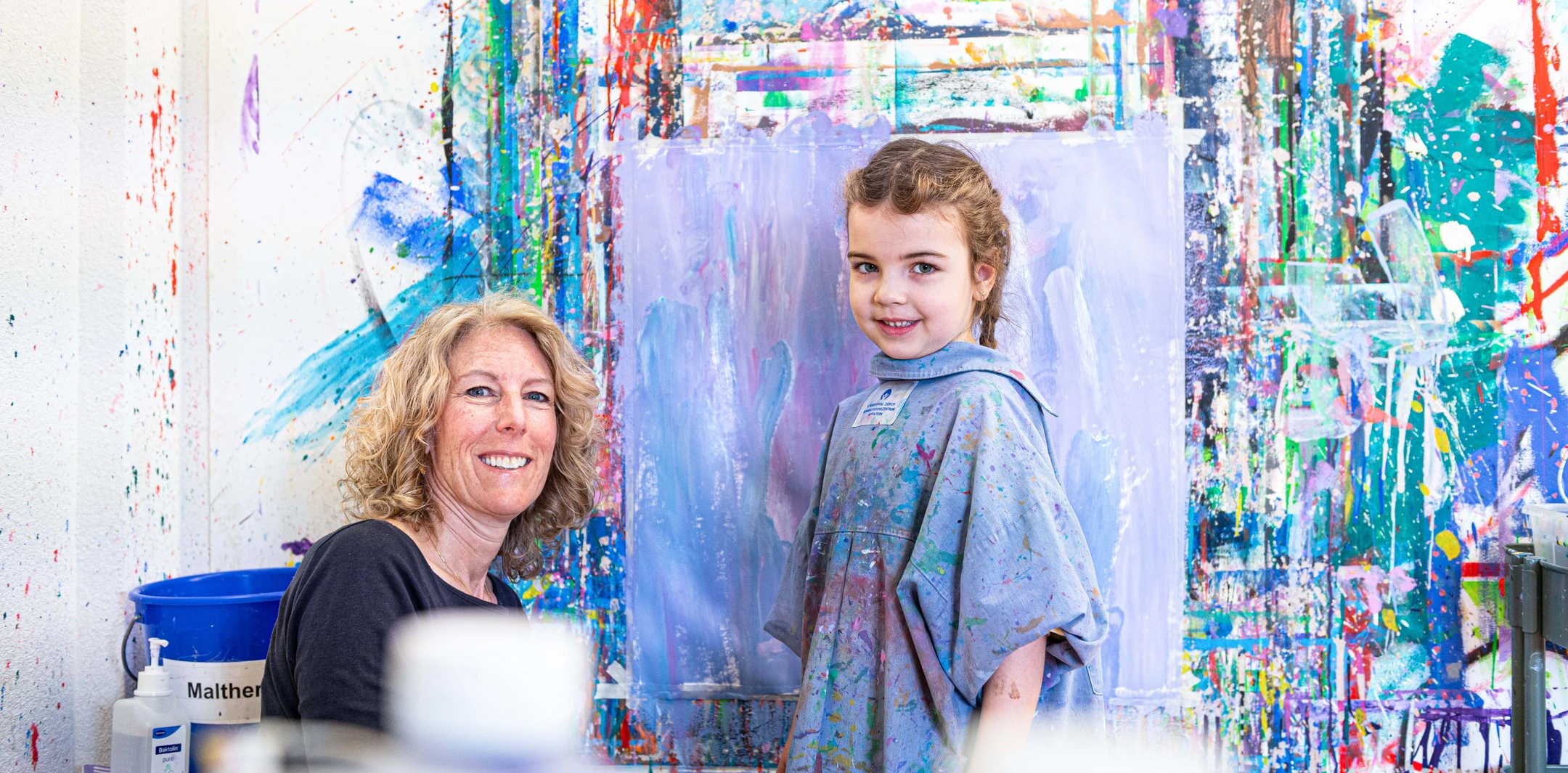 Patientin Vivian in der Kinder-Reha Schweiz präsentiert ihr gemaltes Bild auf einer Leinwand.