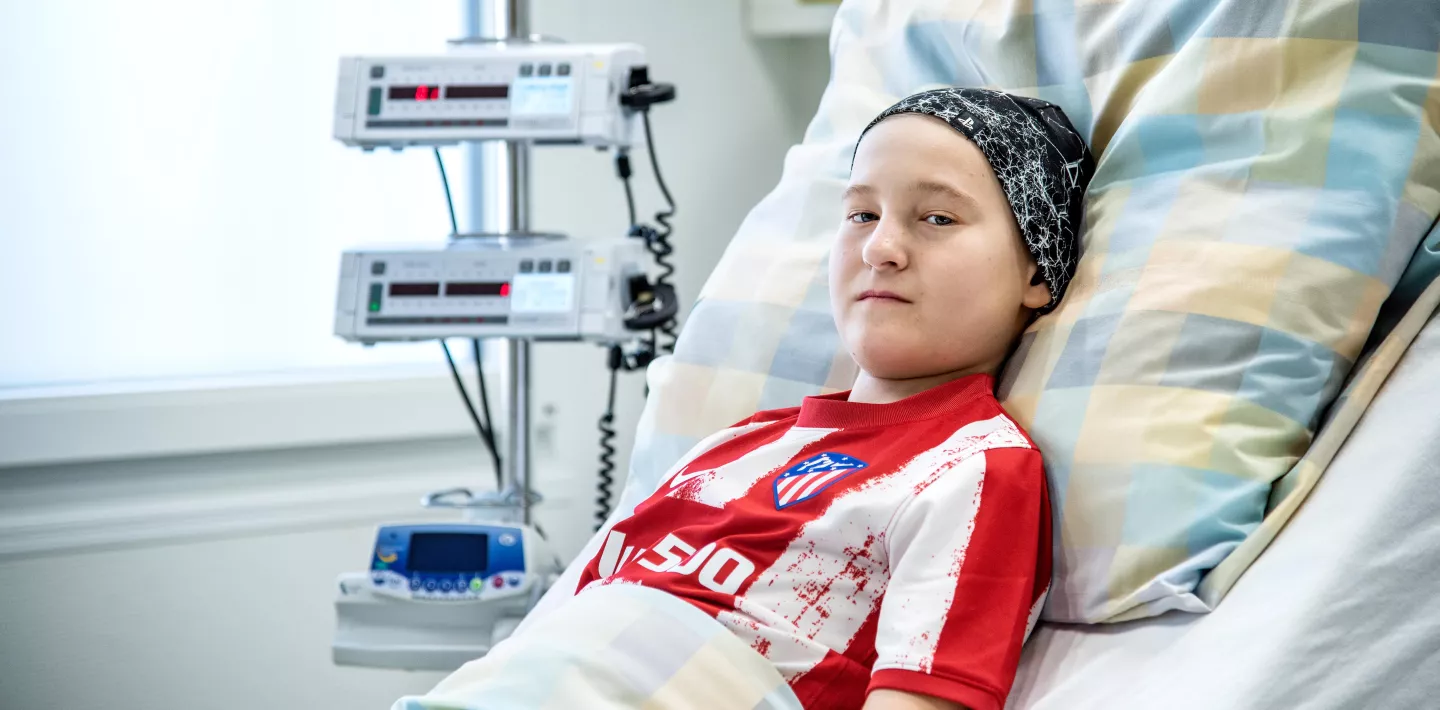 Krebskranker Knabe liegt im Patientenbett
