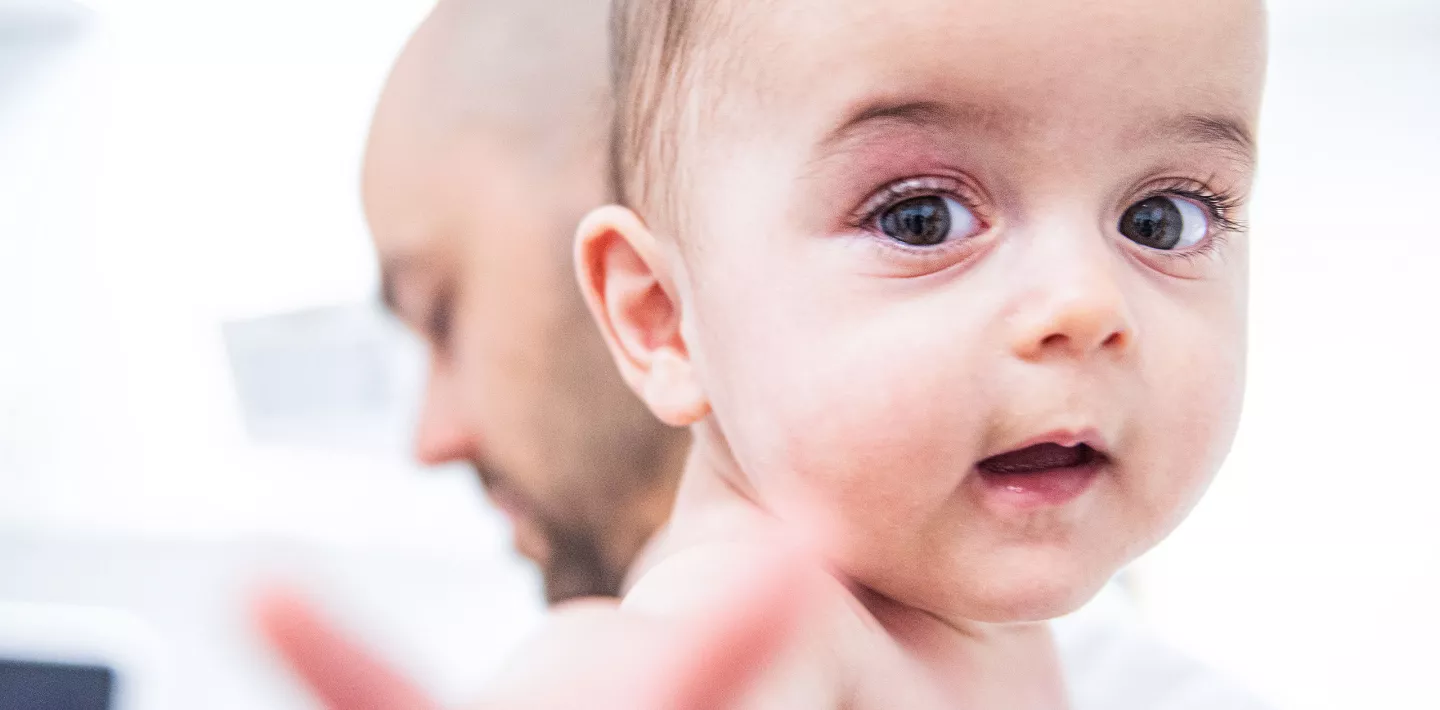 Patientin Alba auf dem Arm ihres Vaters