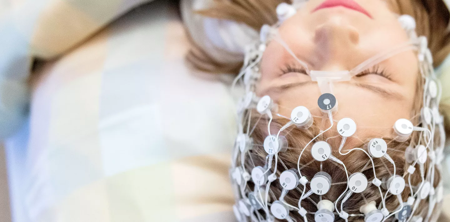 Junges Mädchen mit Elektrodennetz auf dem Kopf während eines Schlaf-EEG.