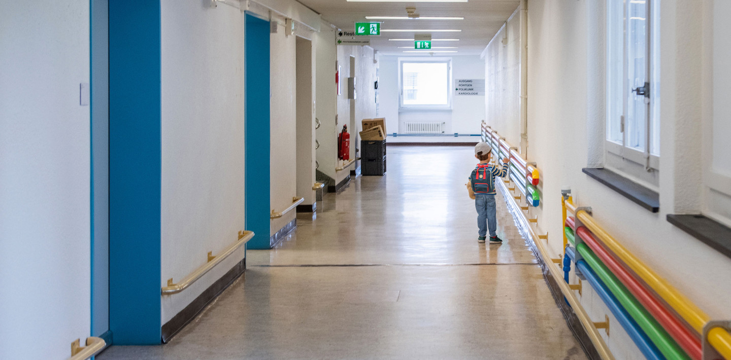 Ein Kind steht auf dem Flur des Kinderspitals Zürich