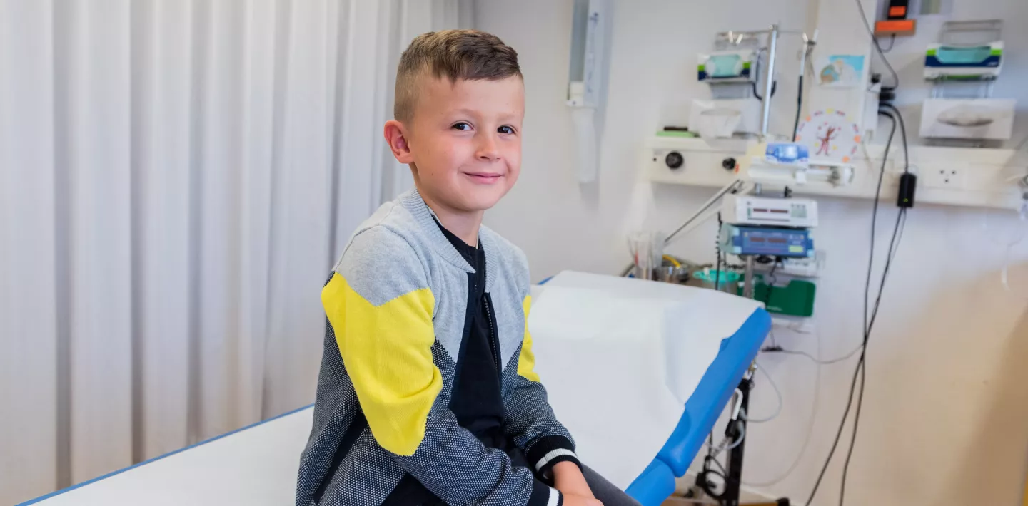 Patient sitzt auf Behandlungsliege 