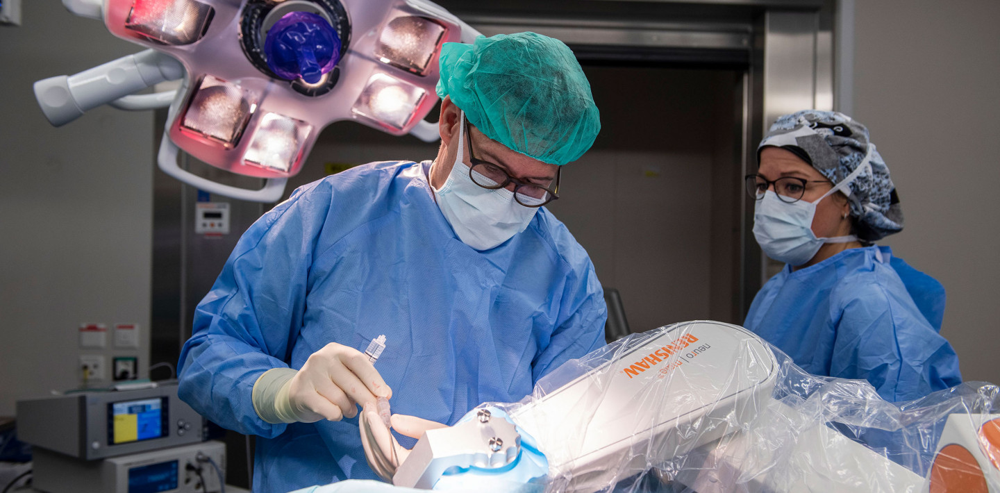 Neurochirurg Niklaus Krayenbühl während eines chirurgischen Eingriffs mit Robotersystem neuromate