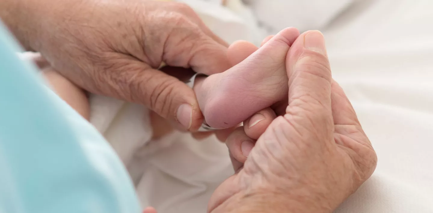 Physiotherapie, Therapeutin massiert sanft Fuss eines Patienten