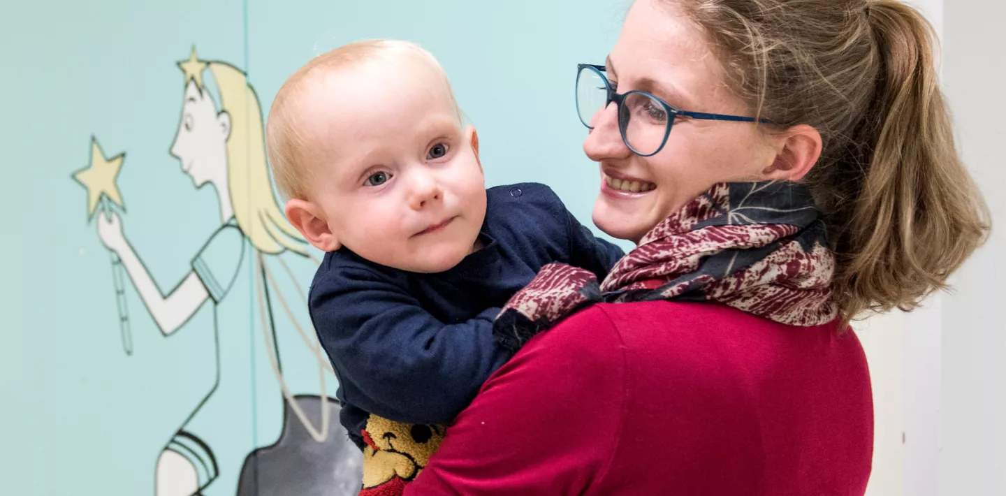 Spina bifida Patient auf Arm der Mutter 