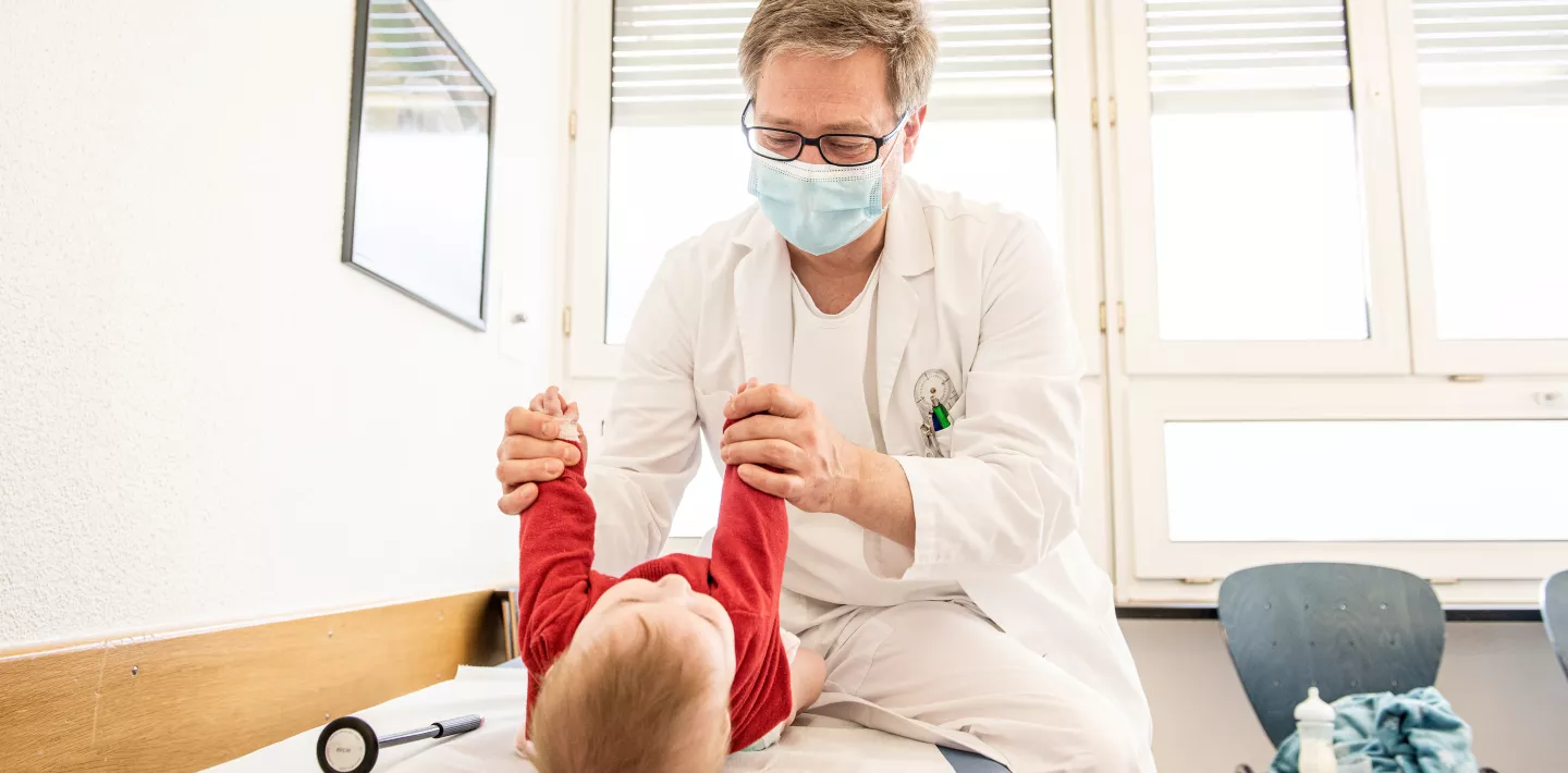 Ein Arzt untersucht ein Baby. 