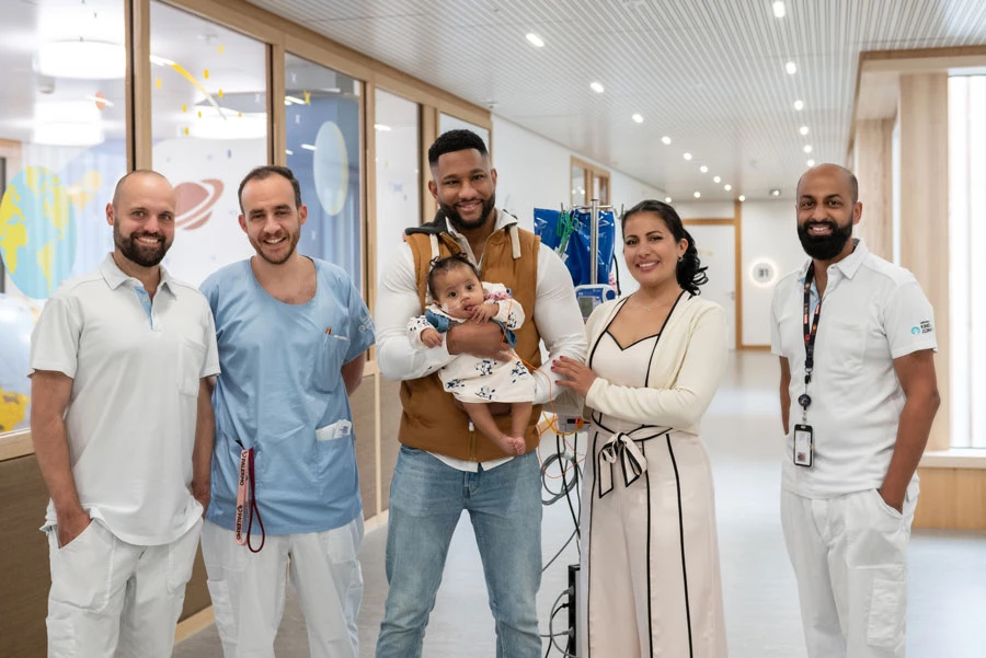Zoe zusammen mit ihrer Mutter, ihrem Vater und drei behandelnden Ärzten.