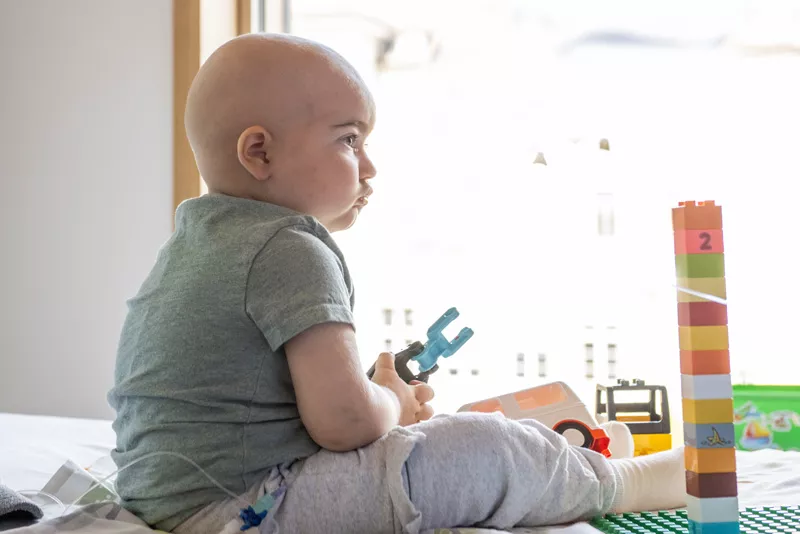 Ali sitzt alleine auf dem Bett