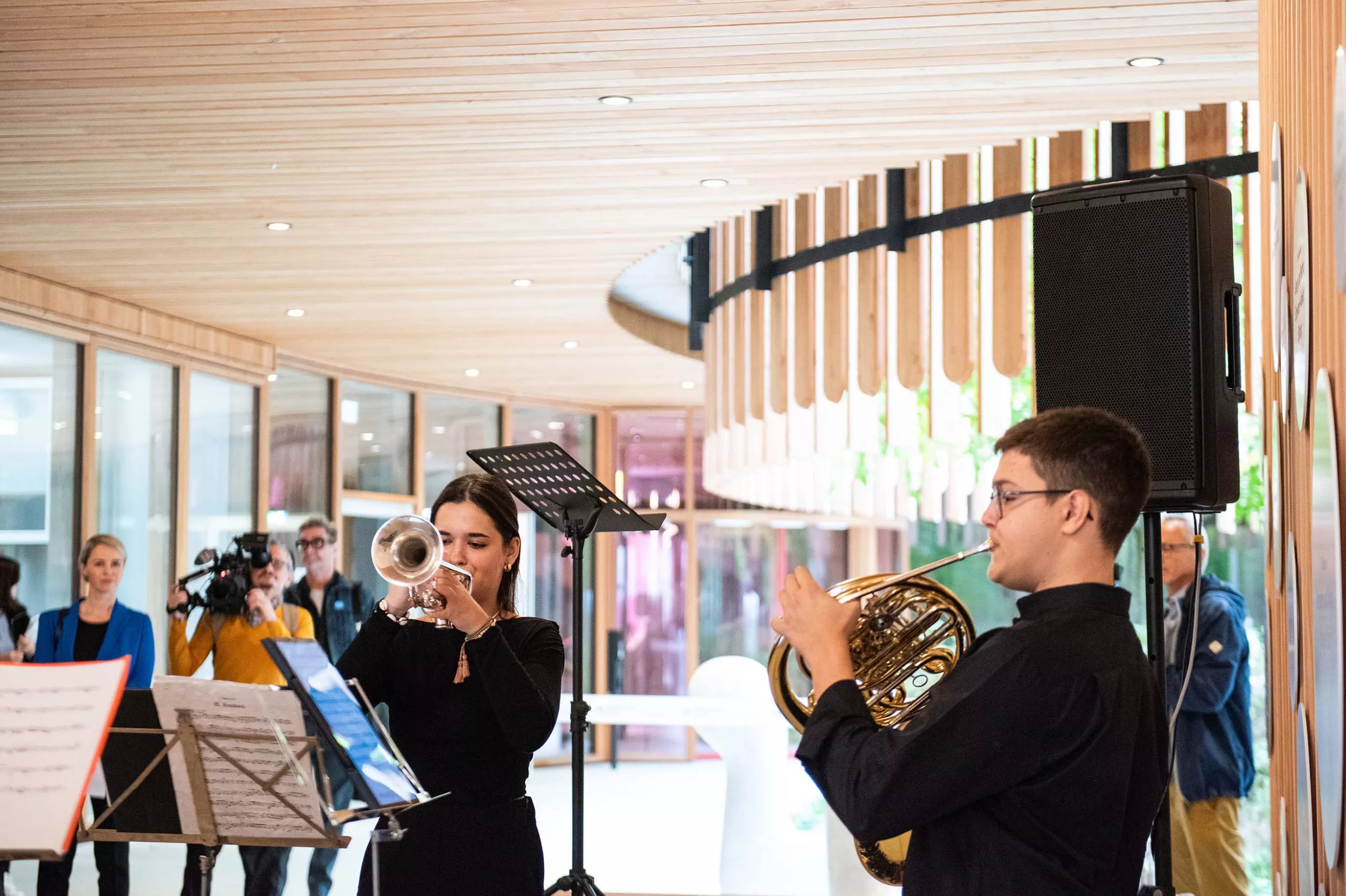 Zwei Musiker und eine Musikerin spielen Blechblasinstrumente vor dem Eingang des Kinderspitals Zürich