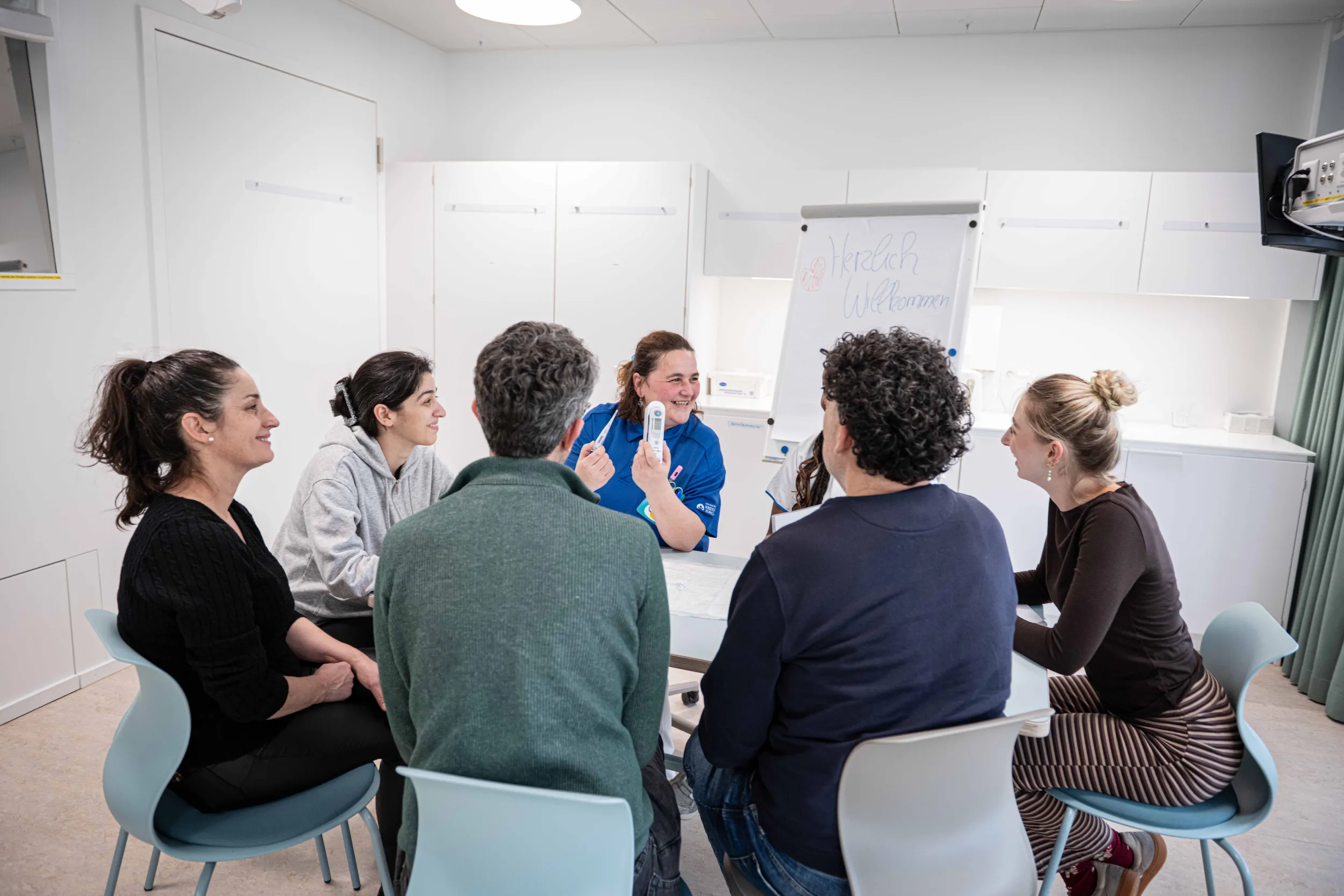 Zwei Expertinnen Notfallpflege erklären Eltern und Angehörigen Erste-Hilfe-Massnahmen für Kinder in einem Seminar