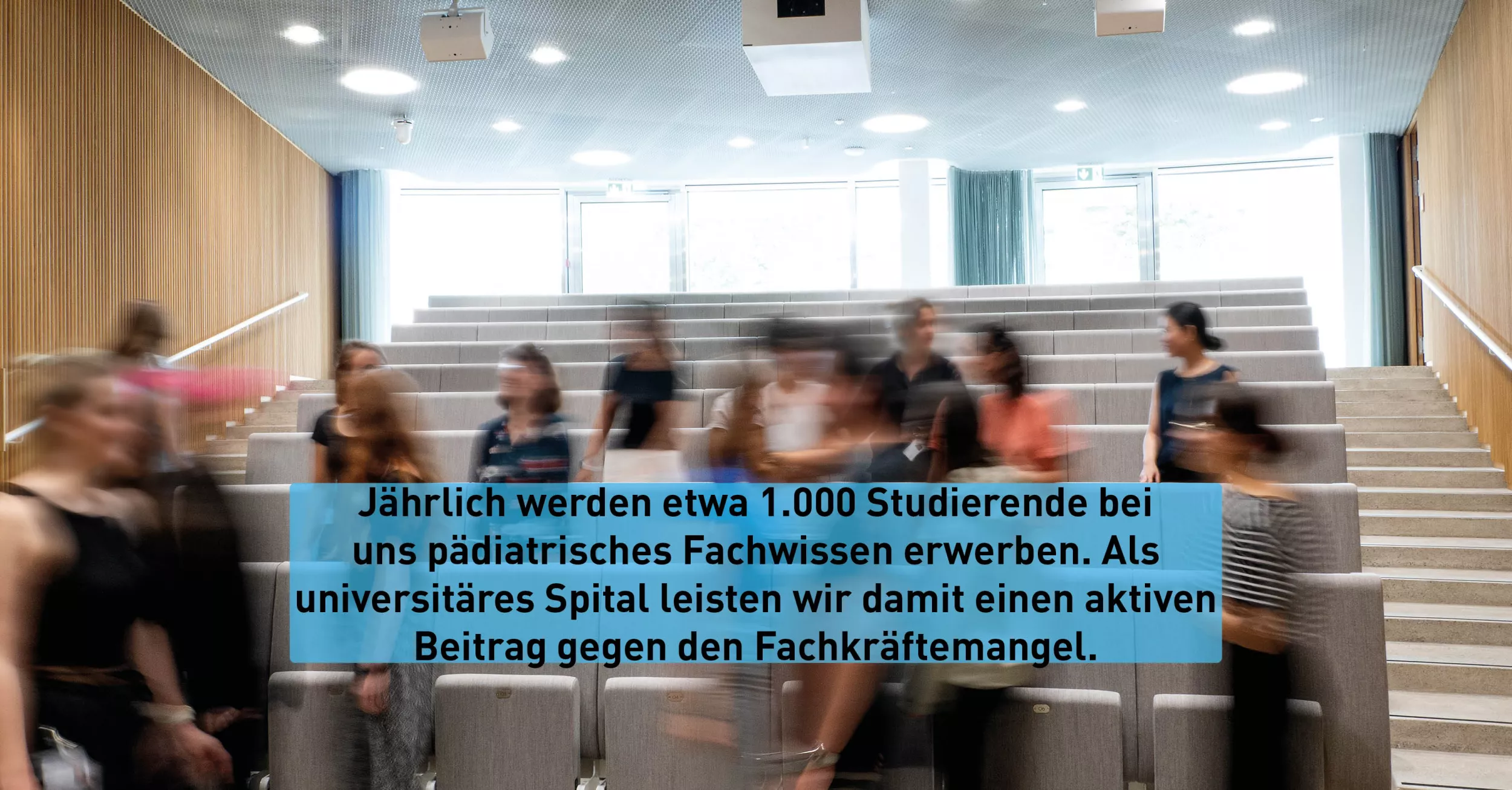 In einem Hörsaal im Gebäude für Forschung und Lehre befinden sich mehrere Personen.