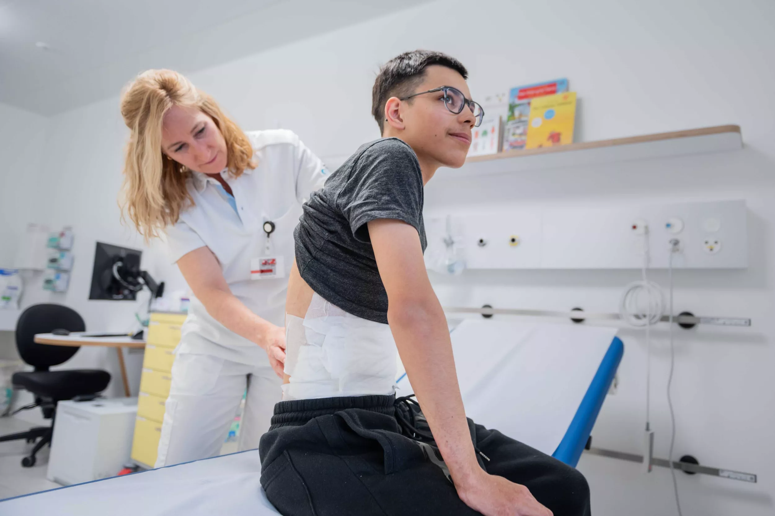 Dr. Sophie Böttcher untersucht Rücken von Patient Diego.