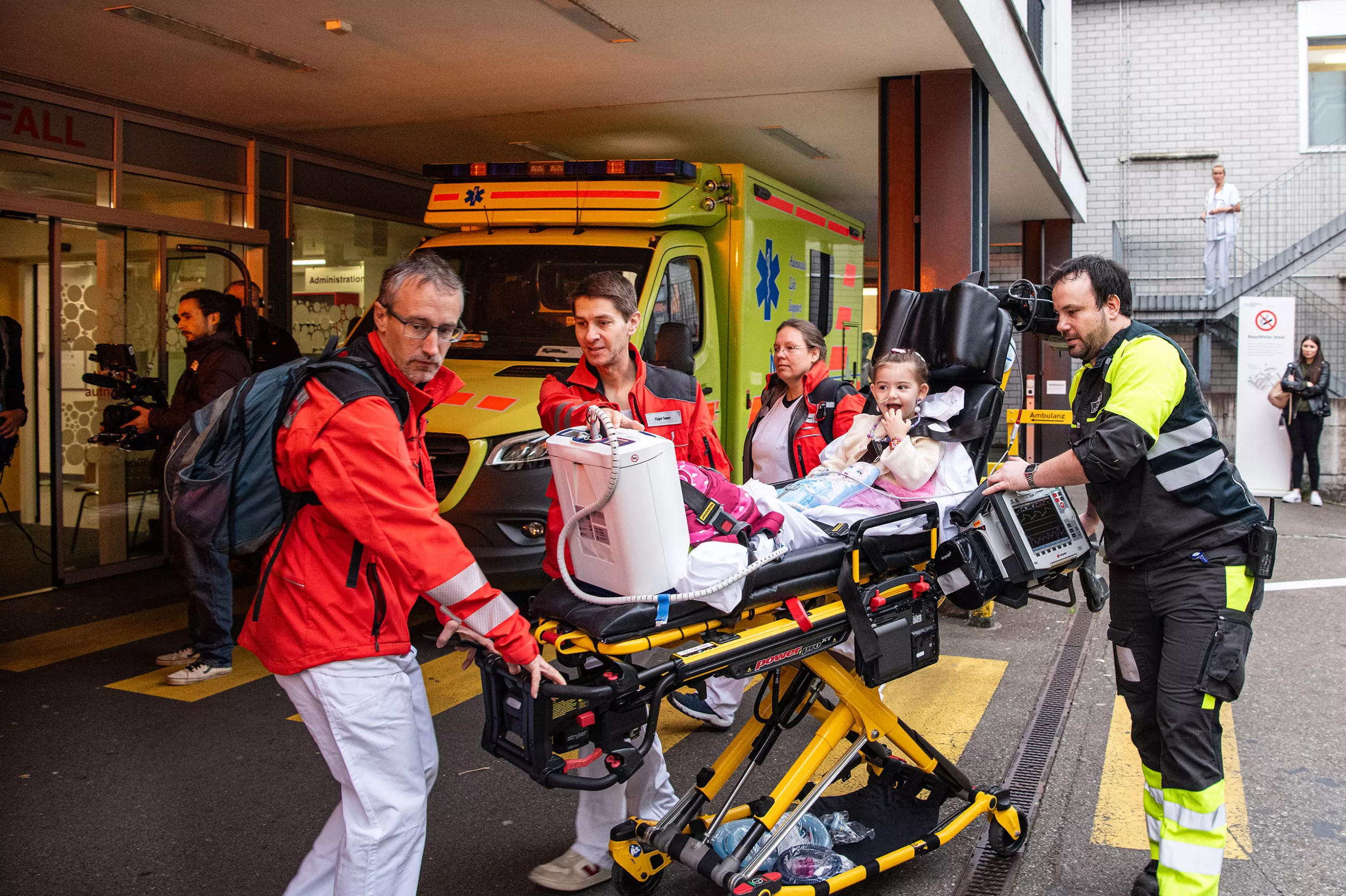 Rettungssanitäter und medizinische Fachpersonen transportieren ein junges Mädchen auf einer Transportliege